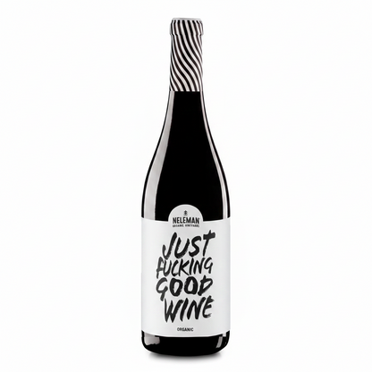 A bottle of Neleman Organic Red Wine with a bold white label reading 'JUST FUCKING GOOD WINE' in black lettering, topped with a black and white striped foil, set against a solid peach background.